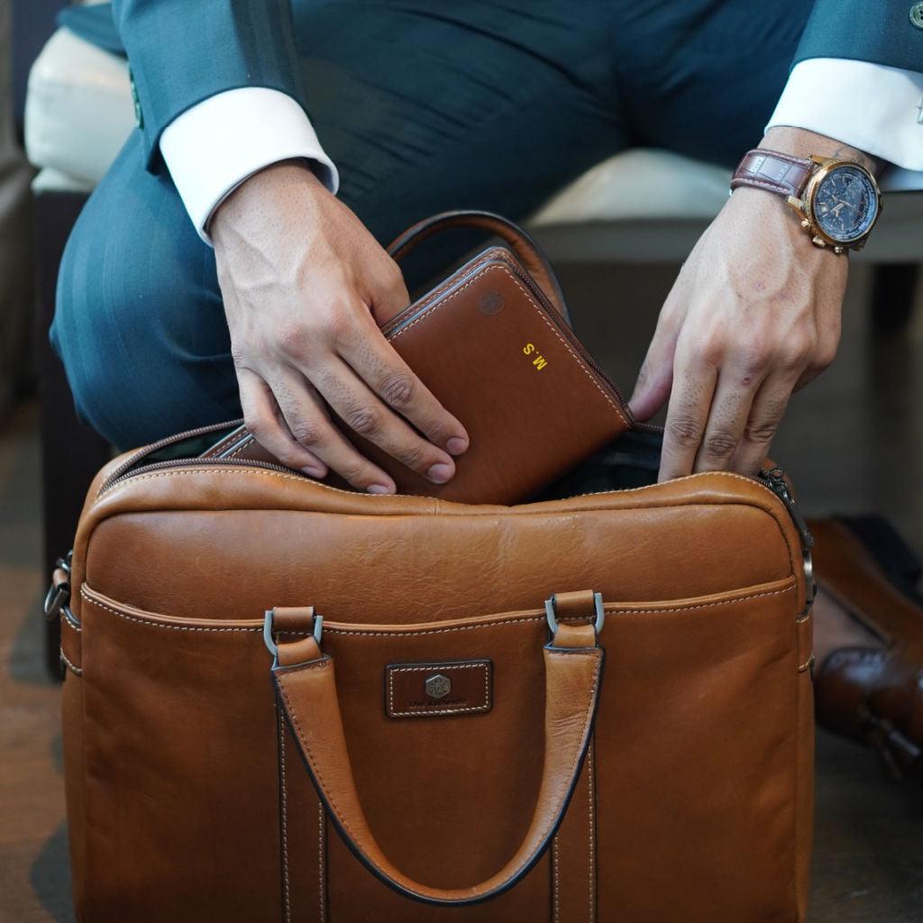 Large zip-around travel and passport organiser in clay leather by Jekyll & Hide, being put into bag